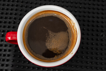 Red cup of americano coffee on black background for breakfast.Top view hot black coffee in restaurant make by barista on best of menu in the coffee shop.Refresh menu.
