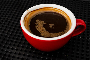 Red cup of americano coffee on black background for breakfast.Top view hot black coffee in restaurant make by barista on best of menu in the coffee shop.Refresh menu.