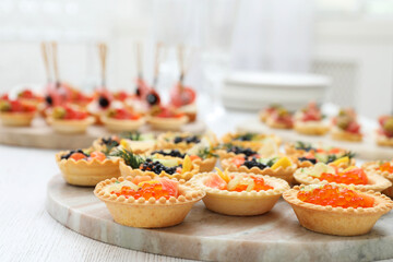 Many different tasty canapes on white wooden table, closeup