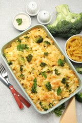 Tasty pasta casserole with cheese and broccoli served on grey table, flat lay