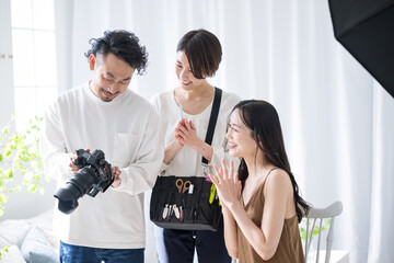 撮影の仕上がりをモデルさんとメイクさんに見せるカメラマン