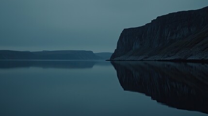 Serene twilight landscape reflecting cliffs and calm waters in a remote wilderness setting