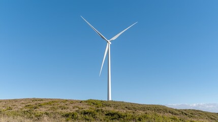 Wind turbine on a hill, clear sky, renewable energy