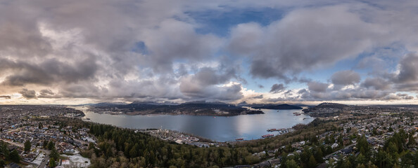 Panoramic View of Coastal City and Mountains Under Dramatic Cloudy Sky