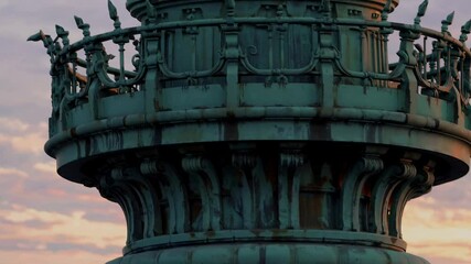 Aerial video shot of the Statue of Liberty at sunset, capturing the iconic landmark with the New York City skyline in the background.