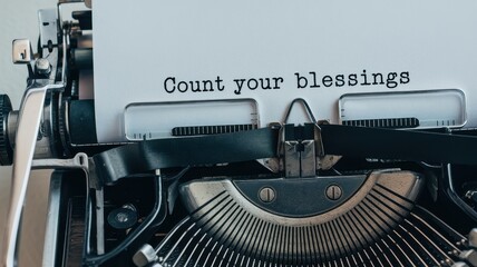 An old fashioned typewriter displays the inspirational quote count your blessings