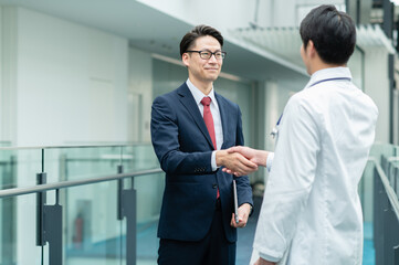 握手をするビジネスマン【撮影協力：スカパー東京メディアセンター】