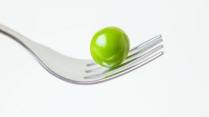A single, vibrant green pea delicately balanced on the tines of a silver fork. A minimalist food photography concept.