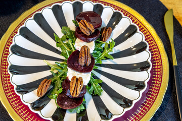 Beet and goat cheese salad on a bed of arugula with candied pecans