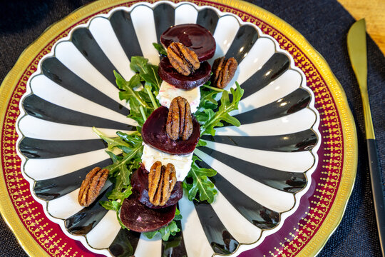 Beet and goat cheese salad on a bed of arugula with candied pecans - Powered by Adobe