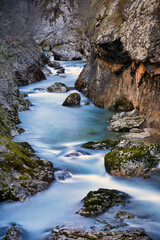 Stream flows gently over rocks and through a canyon of rocks captured with a long exposure time