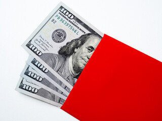 Close up 100 dollars bill banknote cash, money fan with Benjamin Franklin's face image in red envelope packet, isolated background. One hundred numbers on bill banknotes piles, top view.