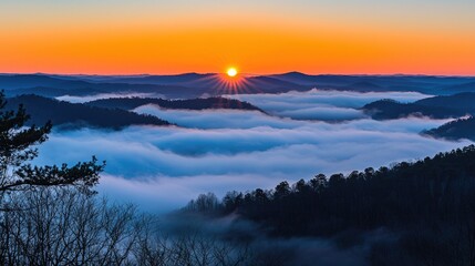 Fototapeta premium Sunrise over misty mountains with vibrant sky, showcasing nature's beauty and tranquility