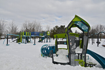 Play equipments covered with snow on the playground in a public park