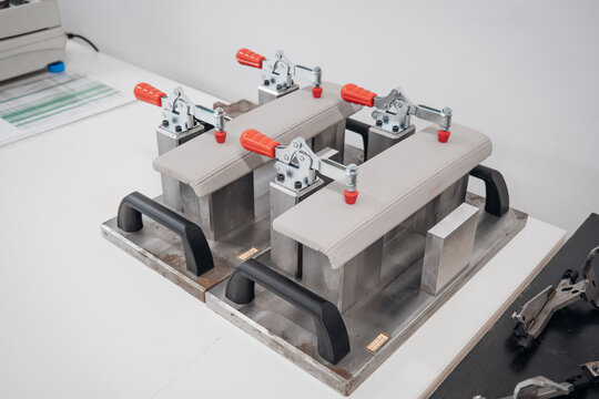 Close up shot of three clamps on a workbench holding upholstered parts in place ready for assembly