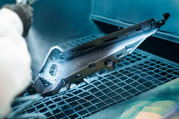 A part being spray painted with a protective coating in an industrial setting Surface finishing...