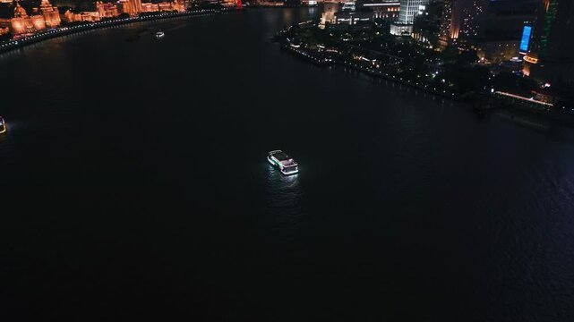 Drone flying around a riverboat on the Huang Pu river, evening in Shanghai