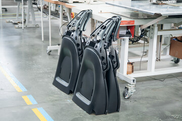 Automotive Interior Panels: Black formed plastic car door trim parts in factory setting Industrial design