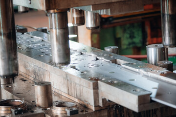 Metal stamping press forming parts with hydraulic pistons in industrial manufacturing environment
