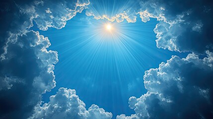 Bright sun rays shining through fluffy clouds in a clear blue sky, evoking tranquility and peace