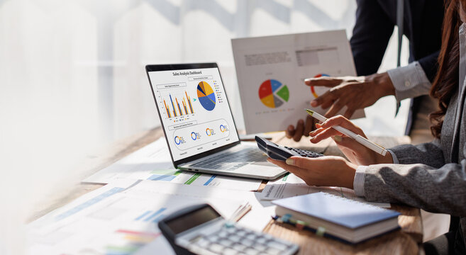 Business people advisor, business people talking, planning analyze investment and marketing analyzing data charts, graphs, and a dashboard on a laptop screen in the office.