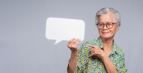 Senior woman holding speech bubble – communication and expression concept.