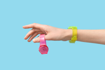 Fototapeta premium Female hand with wristwatches on blue background