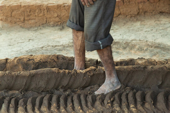 Asia, India, Gujarat,Dasada. Rabari, Mir tribes people. Traditional clay brick making with feet.