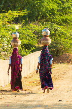 Asia, India, Gujarat,Dasada. Rabari, Mir tribes people. Women carrying pots and jars on their heads.