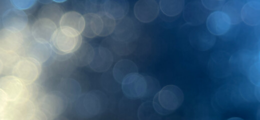 Image shows an abstract background of blurred circles in shades of blue and white creating a bokeh effect. Premium bokeh background for wallpaper, banner and poster.