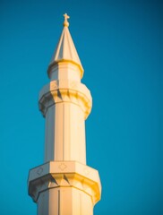 White Mosque Minaret Against Vibrant Blue Sky at Golden Hour