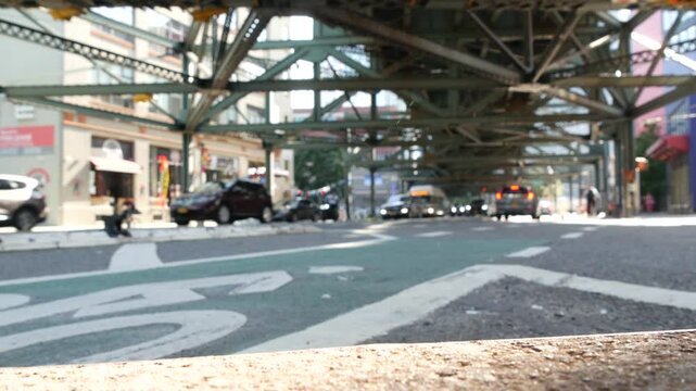 Elevated subway above New York City street. Metropolitan bridge over road, Queens, United States. Long Island overhead metro line, United States. Taxi car under railway track. Yellow cab, Queensboro.