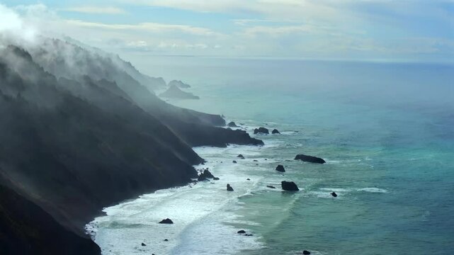 Rugged coastline Lost Coast Trail surf waves USAL Beach campground 4wd aerial drone California cloud layer blue sky mist rain fog PNW waves crashing morning Chimney Rocks nature landscape backwards