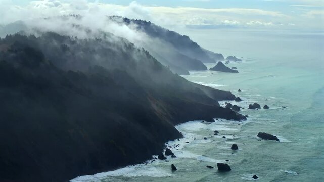 Rugged coastline Lost Coast Trail USAL Beach campground 4wd black sand mist rain fog aerial drone California PNW waves crashing cloud layer morning Chimney Rocks nature landscape backwards motion