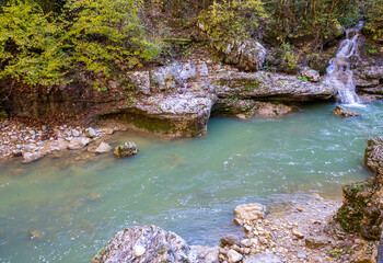 a stream of water in a stone riverbed, spewing noise and rumbling, making its way to free water