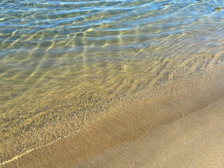 Gentle ocean waves on sand beach.