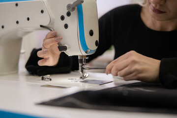 Student engaged in changing the sewing machine needle to continue a project during a sewing lesson at a community center.