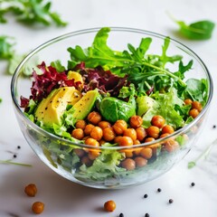 A vibrant salad bowl with mixed greens, roasted chickpeas, avocado