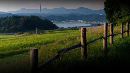 Fototapeta premium Serene Countryside Landscape with Rice Paddies and Distant Mountains