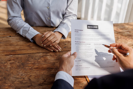 Hands of recruiter holding resume in front of candidate at desk.employee job application concept.