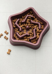 Star shaped slow feeder bowl filled with dog treats