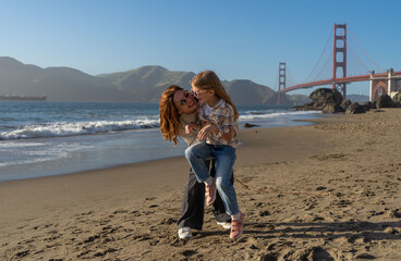 Mother and daughter have fun at the beach, focus on woman