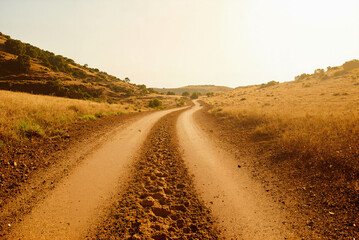 dirt road leading into the distance towards rolling hills