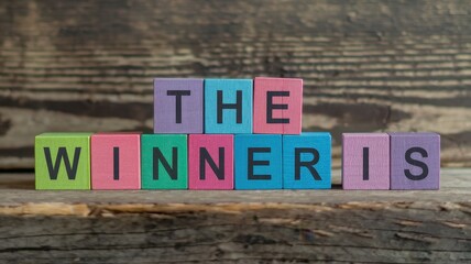 Fototapeta premium Colorful wooden blocks spell out the phrase the winner is
