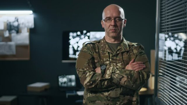 Medium copy space portrait of male adult commander in military uniform posing for camera while working in central hub