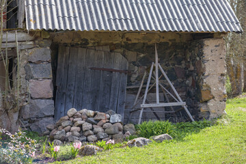 
An old stone building with a slate roof and a wooden door.