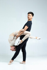 Couple of Asian Man and Caucasian Woman Performing As Ballet Dancers On Grey in Studio During Suppots As Classical Dance And Choreography © danmorgan12