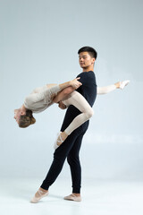 Asian Man and Caucasian Woman Performing As Ballet Dancers On Grey in Studio During Suppots As Classical Dance And Choreography © danmorgan12