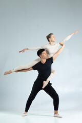 Sporty Asian Man and Caucasian Woman Performing As Ballet Dancers On Grey in Studio During Suppots © danmorgan12