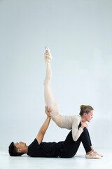 Couple of Asian Man and Caucasian Woman Performing As Ballet Dancers On Grey in Studio During Suppots As Classical Dance And Choreography © danmorgan12
